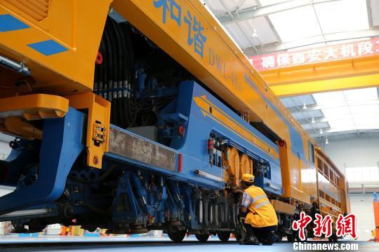 圖為工人正在清理大型養(yǎng)路機(jī)械?！堖h(yuǎn) 攝